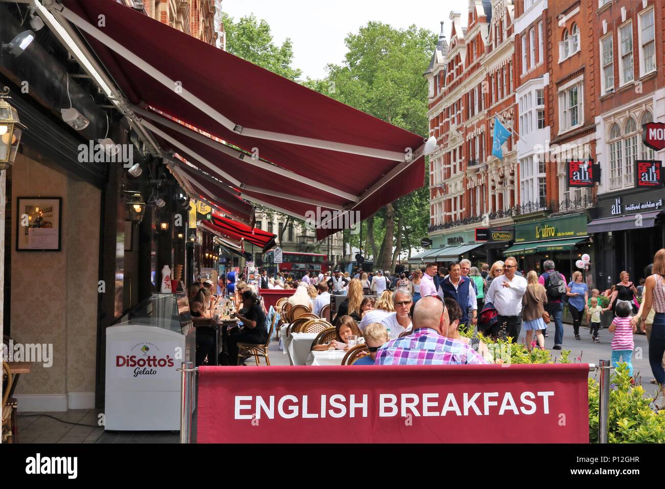 Leicester Square / St Martin's Court area di Londra, UK che mostra la gente camminare intorno al sole. Il teatro e la zona di turismo. Foto Stock