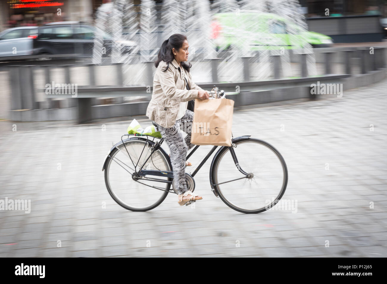 Ciclista pedalando attraverso Ypres, Ieper, sul mercato o Grote Markt Belgio Foto Stock