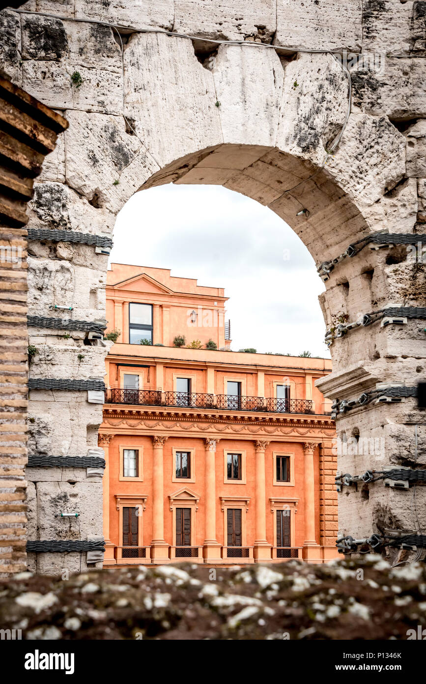 Vista di un moderno edificio di epoca romana attraverso arco nella antica o Colosseo Colosseo, contrastando il vecchio e il nuovo, prospettiva, preso dall'interno del Colosseo Foto Stock