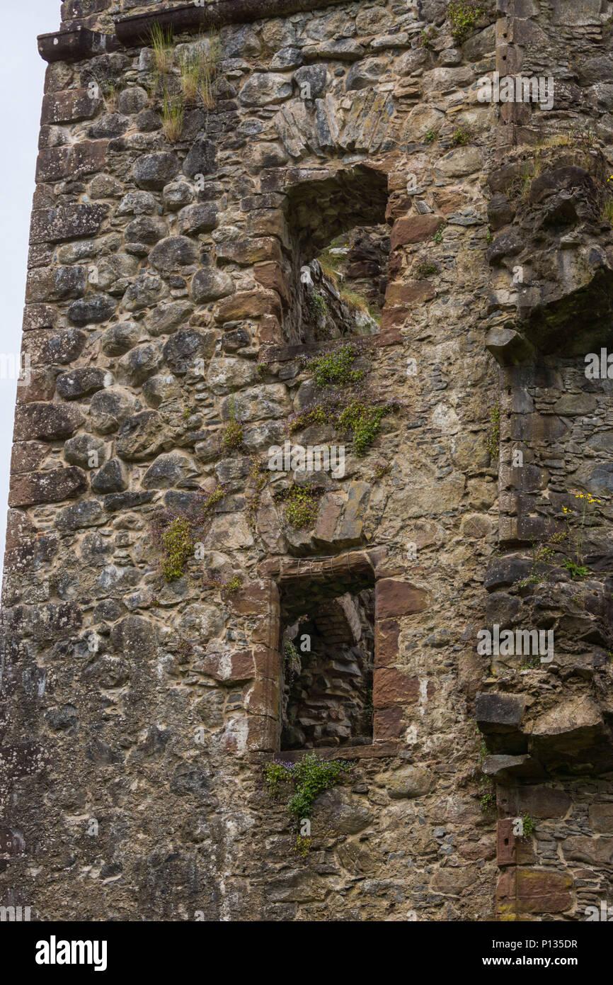 Invergarry, Scozia - Giugno 11, 2012: Closeup di Tall scuro-marrone rovinato parete con aperture a finestra del castello a Invergarry. Foto Stock