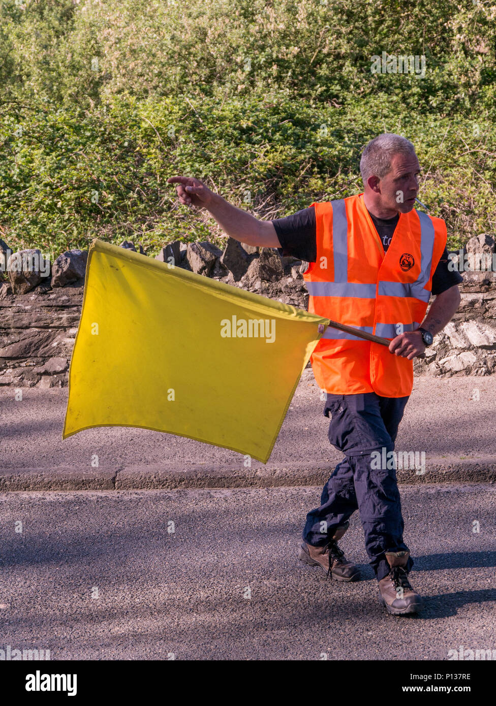 Il Maresciallo del corso con bandiera gialla, Isle of Man TT 2018. Tourist Trophy la gara su strada, corso di montagna Foto Stock