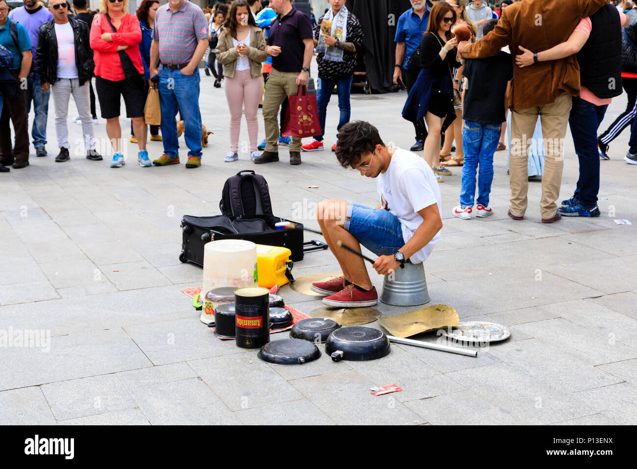 Street intrattenitore busker, tamburellare con tamburo improvvisati set da vecchie pentole e padelle. plaza de la Puerta del Sol di Madrid, Spagna. Maggio 2018 Foto Stock