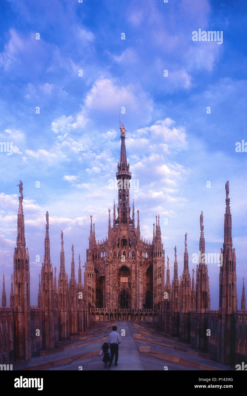 Il Duomo di Milano, visualizzare sul tetto guardando ad est verso la guglia, con il padre e figlia camminando sul tetto e spostando verso la guglia, Milano, Italia Foto Stock