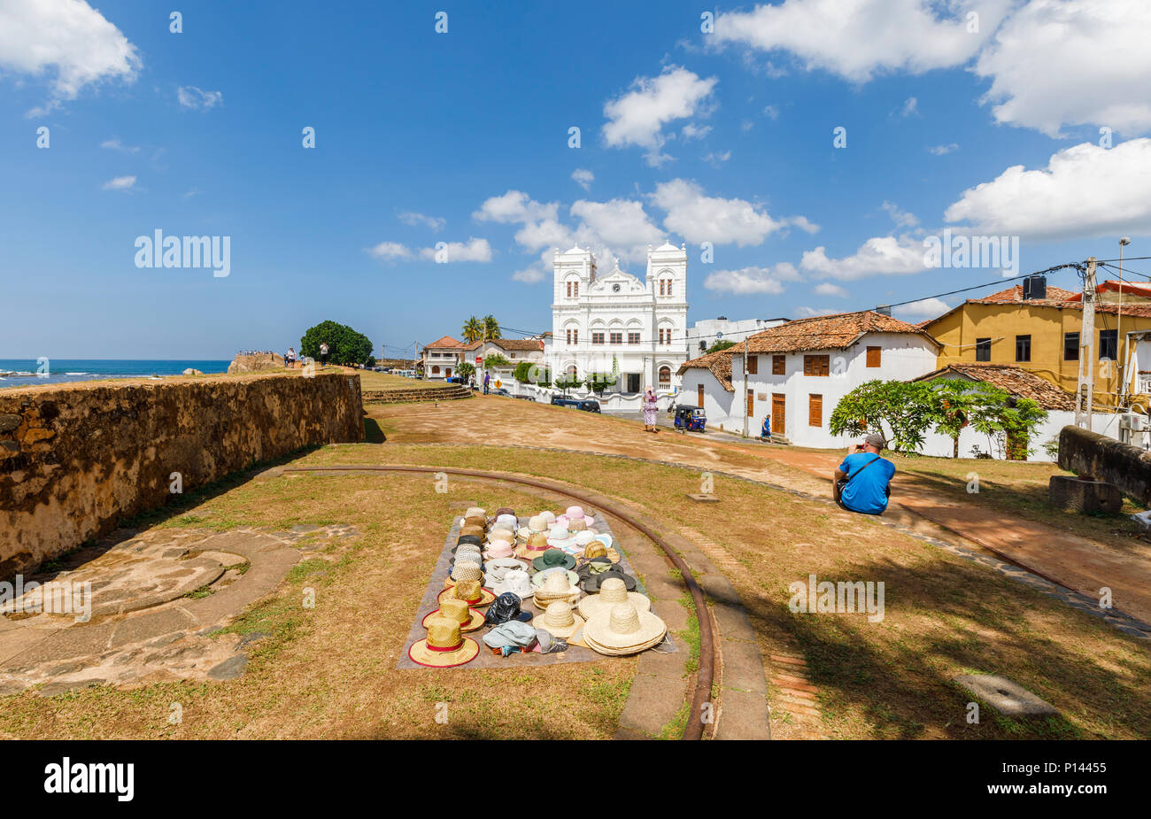 Cappelli stabiliti esposti per la vendita ai turisti sulla Forte Galle bastioni dal bianco iconico Meeran Moschea Jumma, Galle, sud della provincia, Sri Lanka Foto Stock