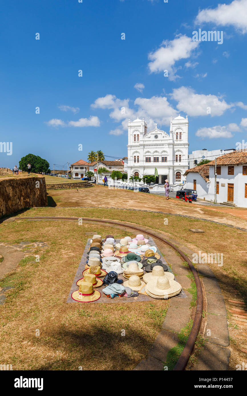 Cappelli stabiliti esposti per la vendita ai turisti sulla Forte Galle bastioni dal bianco iconico Meeran Moschea Jumma, Galle, sud della provincia, Sri Lanka Foto Stock