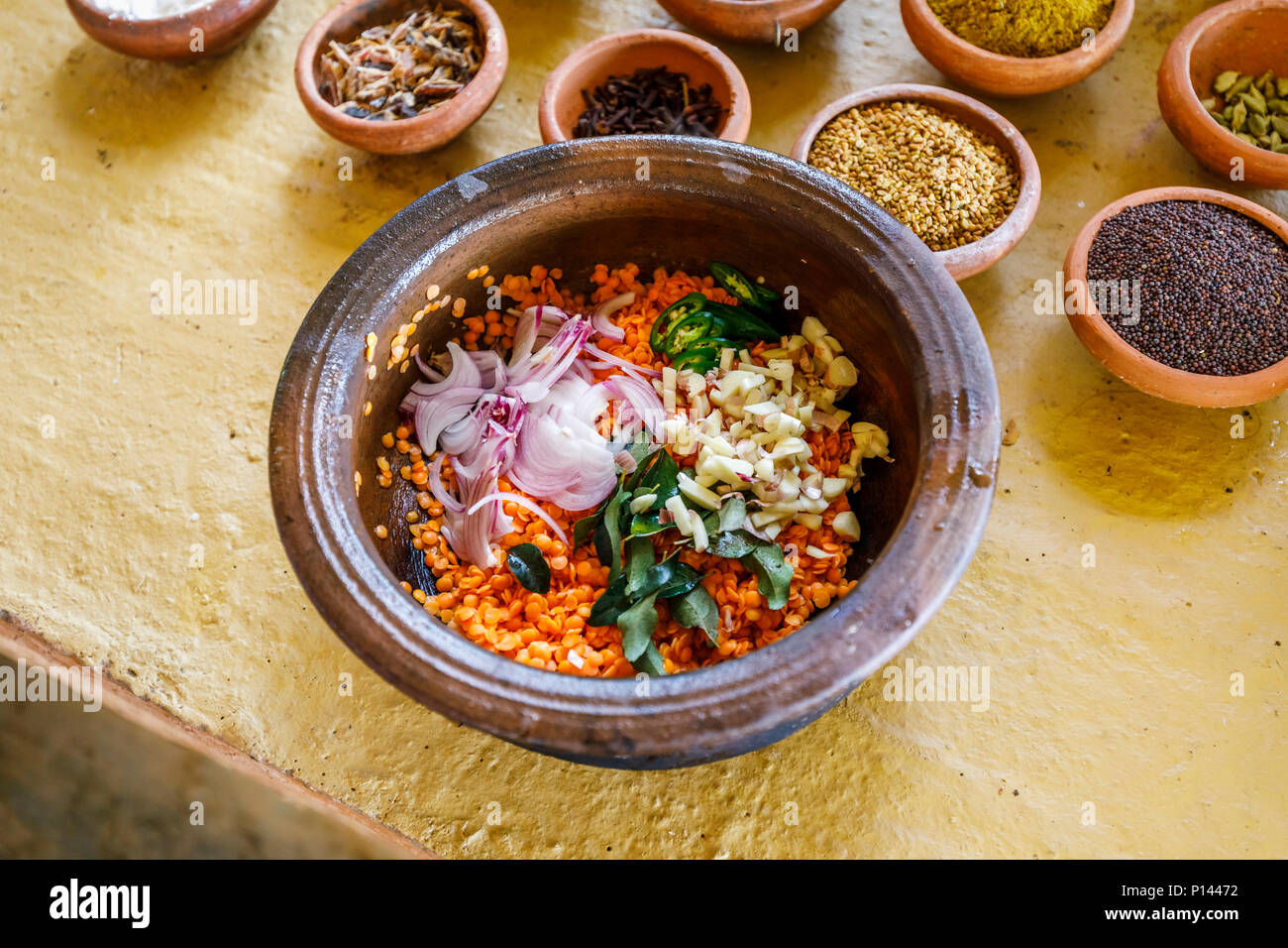 Ciotola di ingredienti per dahl ad una tradizionale ricetta locale: lenticchie, cipolle, aglio e foglie. Horagampita distretto, vicino a Galle, Sri Lanka Foto Stock