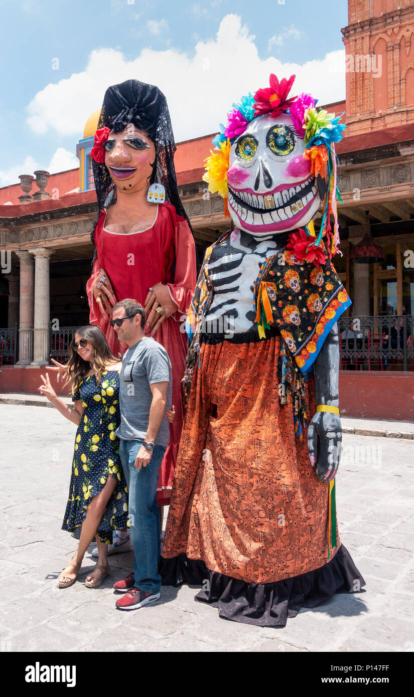 Turista giovane fotografato con due giganti nel centro di San Miguel De Allende Foto Stock