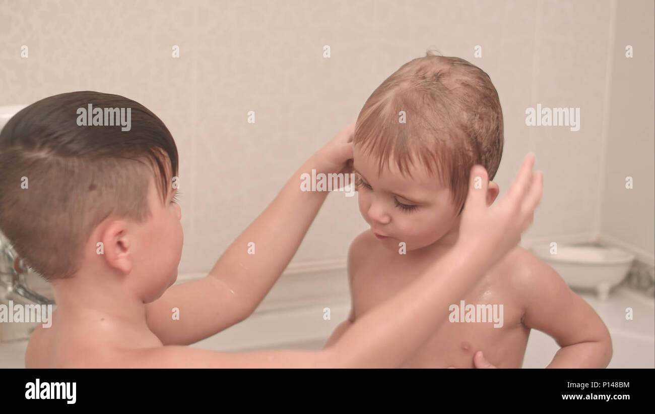 Due ragazzi piccoli si divertono con conchiglia mentre tenendo bagno in vasca  da bagno Foto stock - Alamy