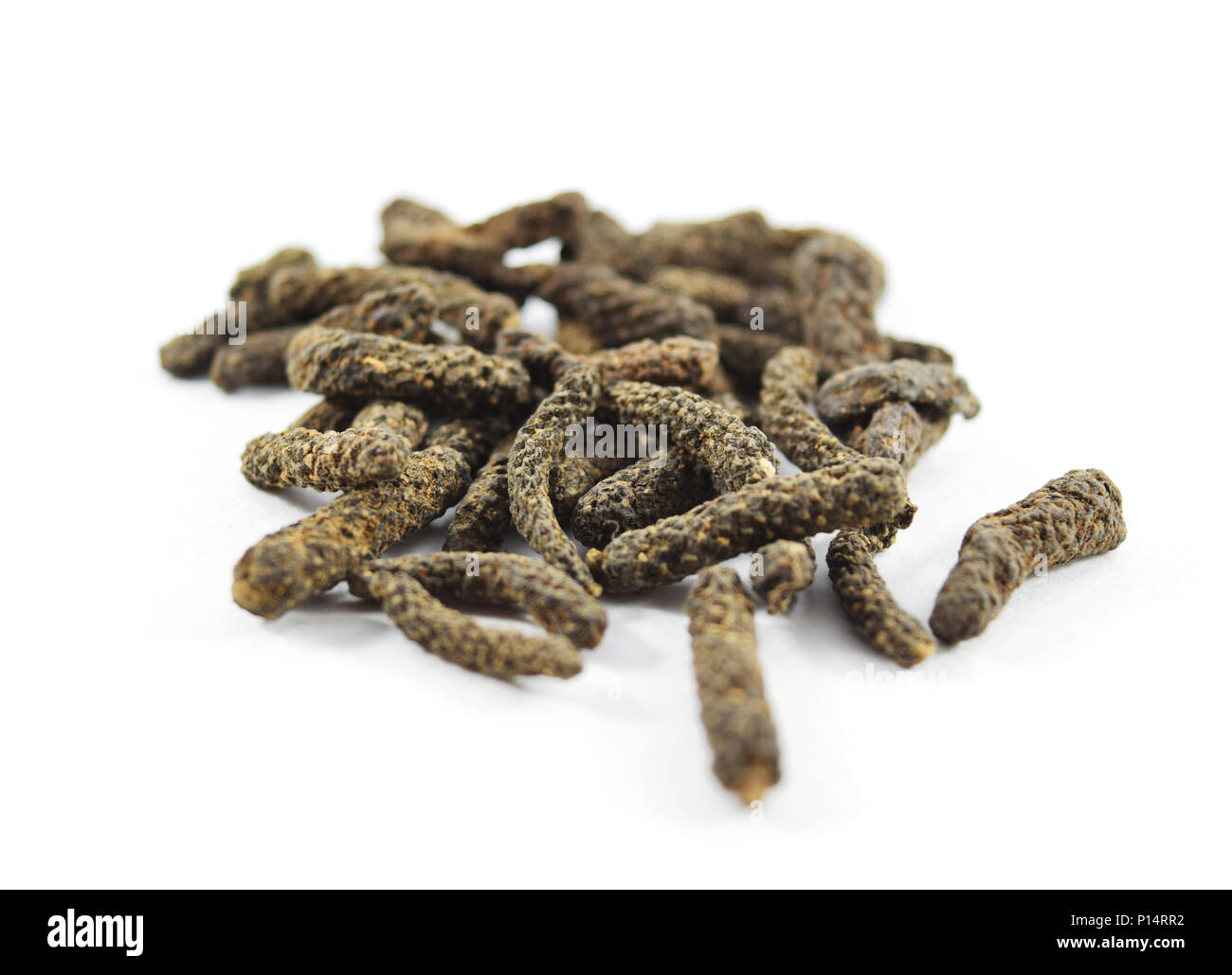Pila di indiani pepe lungo (piper longum) isolato, extreme closeup (macro) Foto Stock