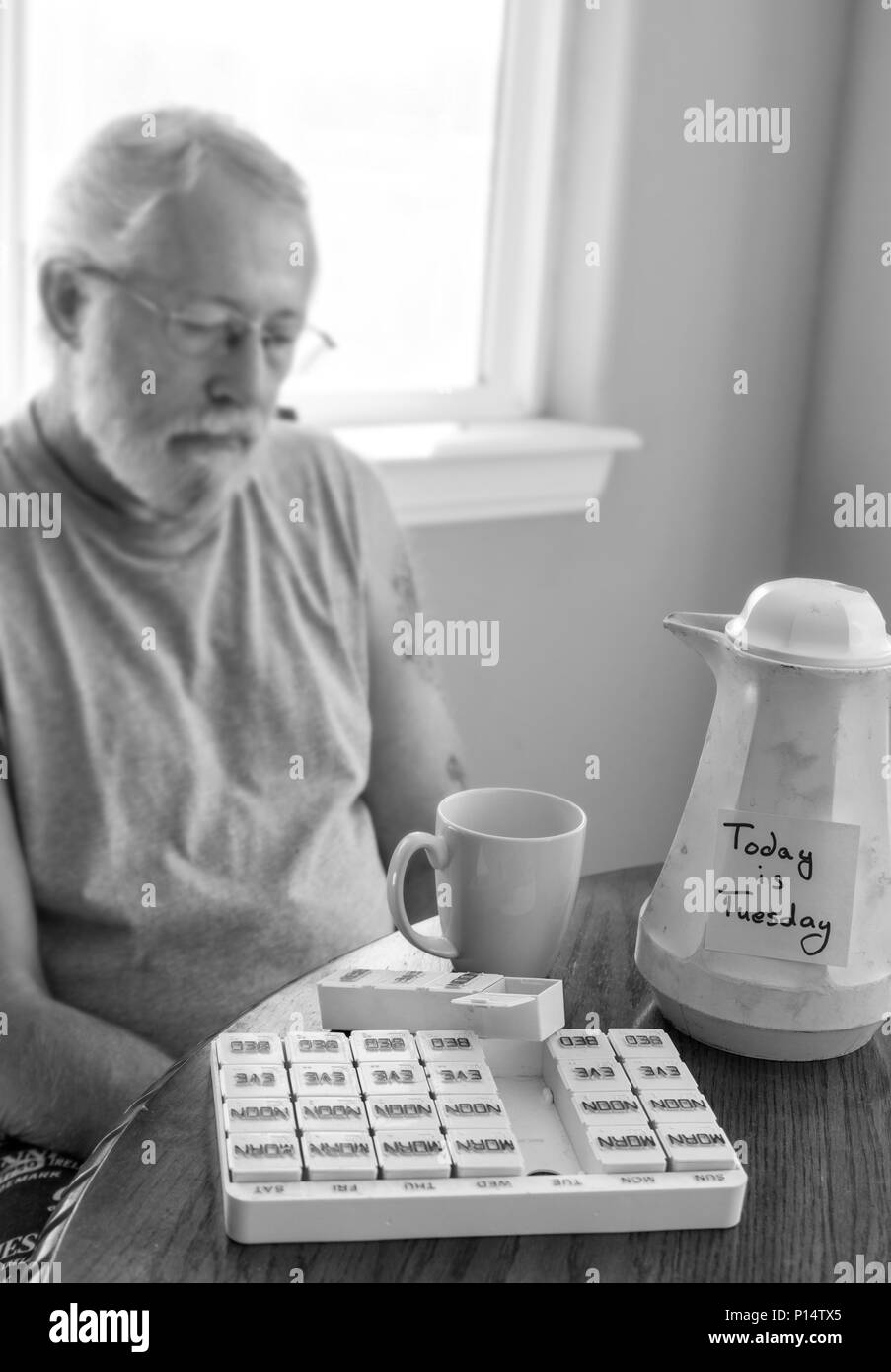 Immagine sfocata del triste uomo con post-it sul caffè vecchio caraffa per ricordargli il giorno della settimana Foto Stock