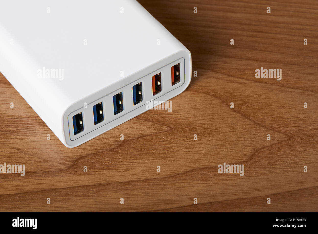 Primo piano della multiport stazione di carica veloce su un sfondo di legno Foto Stock
