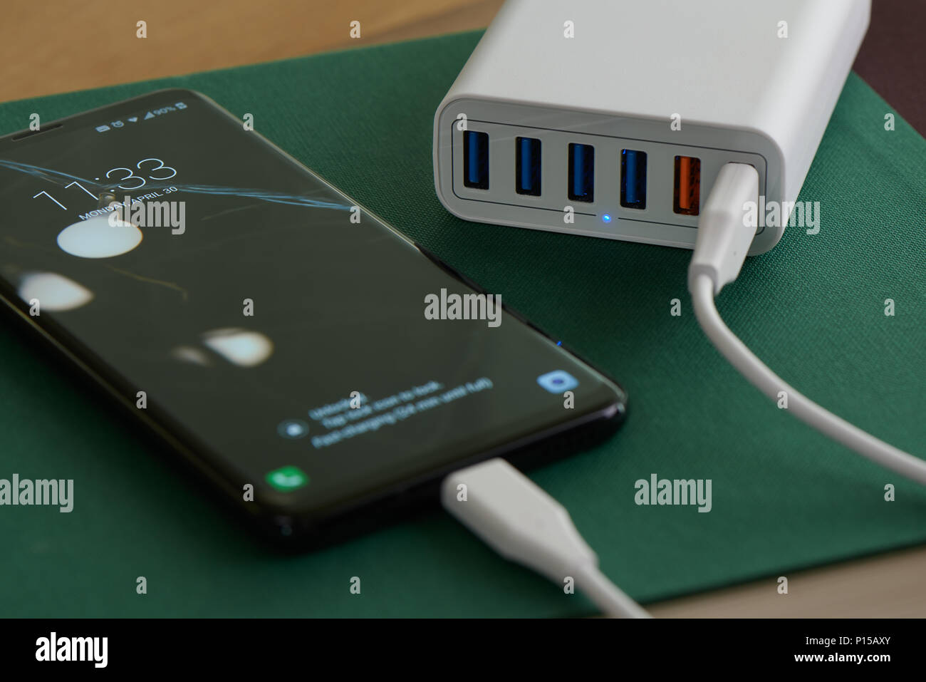 Multiport di stazione di ricarica e di rapido caricamento dello smartphone su una scrivania. Foto Stock