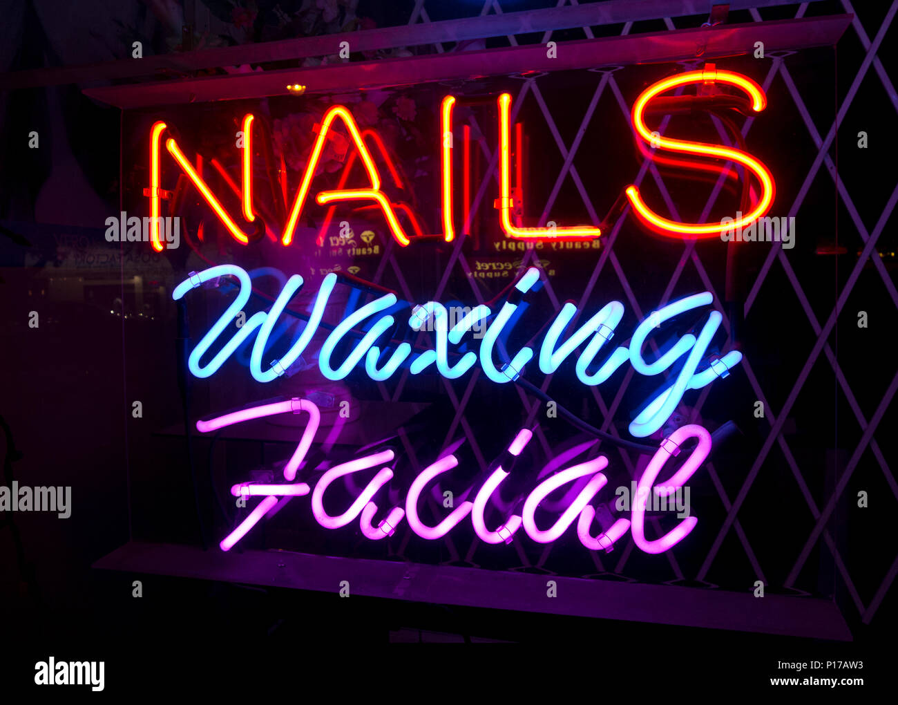 Chiodi ceretta viso segno al neon per un salone di bellezza. Foto Stock