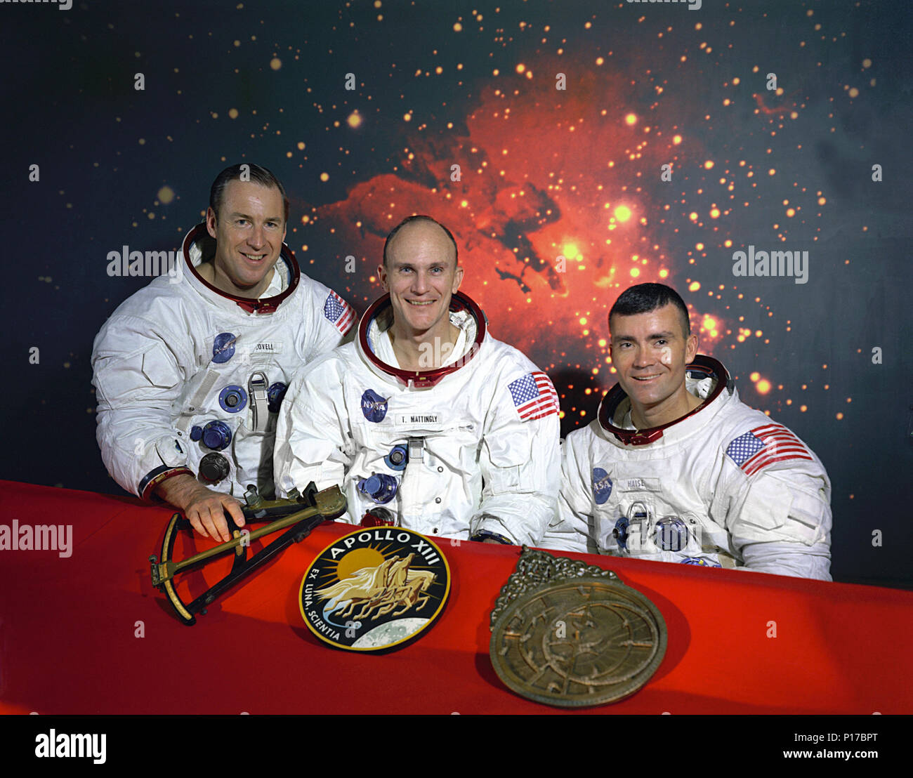 L'originale Apollo 13 primo equipaggio. Da sinistra a destra sono: Comandante James A. Lovell, il pilota del modulo di comando, Thomas K. Mattingly e modulo lunare pilota, Fred W. Haise. Sul tavolo di fronte a loro sono da sinistra a destra, un modello di un sestante, l'Apollo 13 insegne, e un modello di astrolabio. Il sestante e astrolabio sono due antiche forme di navigazione. Il pilota del modulo di comando Thomas "Ken Mattingly" è stata esposta per morbillo tedesco prima della sua missione ed è stato sostituito dal suo backup, il pilota del modulo di comando, John L. 'Jack' Swigert Jr. Foto Stock