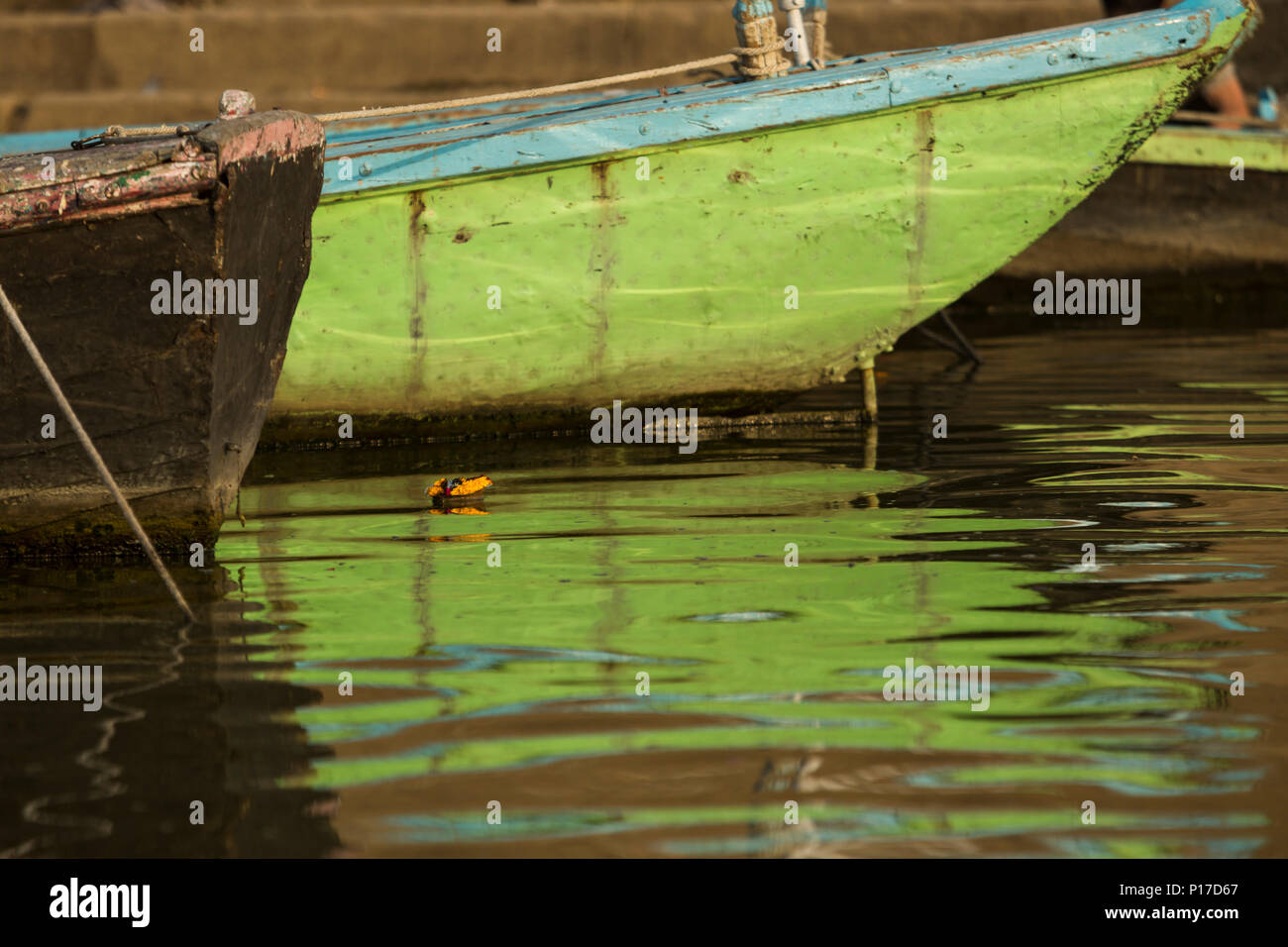 Barca verde nelle sacre acque del fiume Gange. Varanasi, India Foto Stock