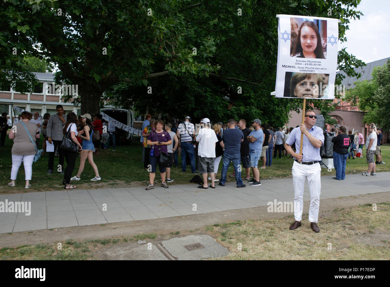 Un diritto-wing protester sorregge un poster con le foto di Susanna F. e Angela Merkel che legge 'Susanna F. - Merkel, la vostra politica mi ha ucciso". A destra i manifestanti del Beweg era Deutschland (spostarlo Germania) movimento tenere i loro regolari bi-settimanale governo anti-rally in Mainz. Questo settimane la protesta si è svolta sotto il pretesto di una veglia per l'adolescente Susanna F, che sarebbe stato ucciso da un rifugiato a Wiesbaden, il rally è stato affrontato da diversi anti-casse del governo, che ha chiesto al governo di dimettersi. (Foto di Michael Debets/Pacific Stampa) Foto Stock