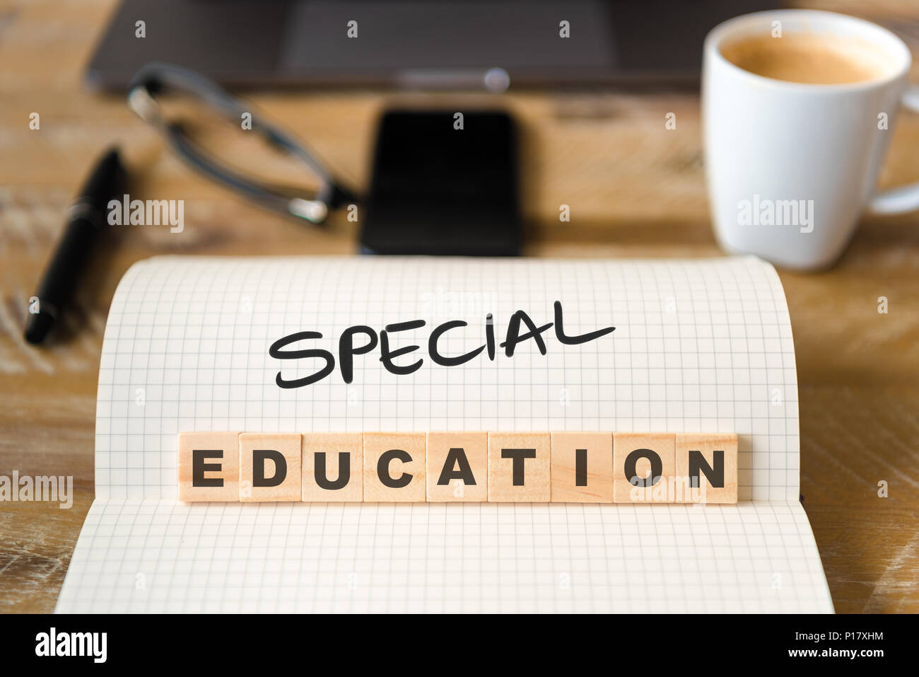 Primo piano su notebook sulla scrivania vintage superficie, di fronte a fuoco sui blocchi di legno con lettere che l'educazione speciale di testo. Foto Stock