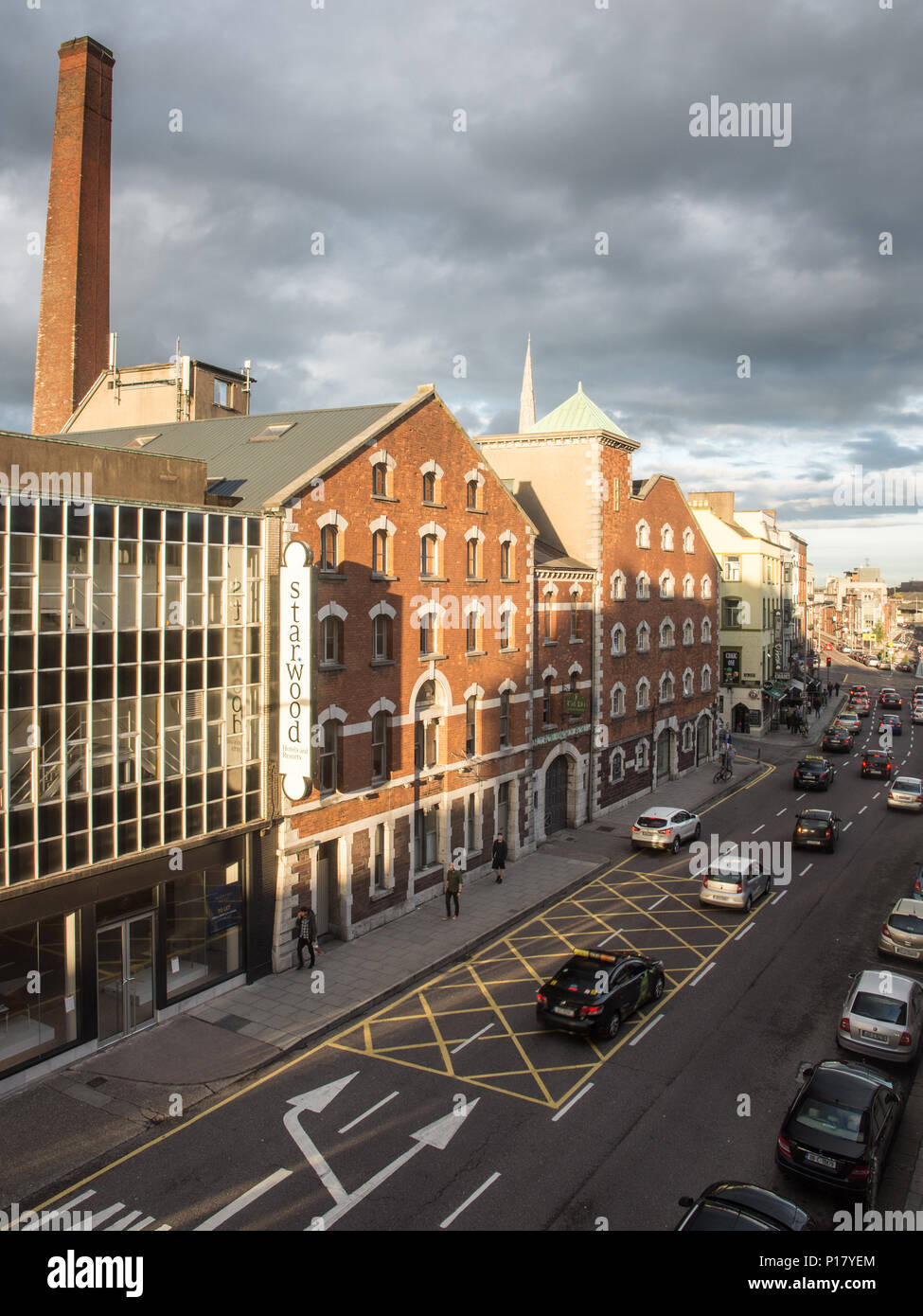 Cork, Irlanda - 15 Settembre 2016: il traffico passa la tradizionale fabbrica di mattoni di edificio Thompson's Bakery su MacCurtain Street nel centro di Cork. Foto Stock