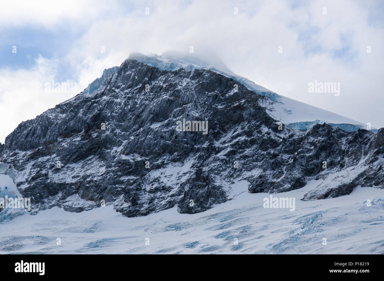 Montagna innevata, primo piano. Neve sgrossato e rabboccato vertice con picco roccioso faccia. Montagne delle Ande, Cile. Foto Stock