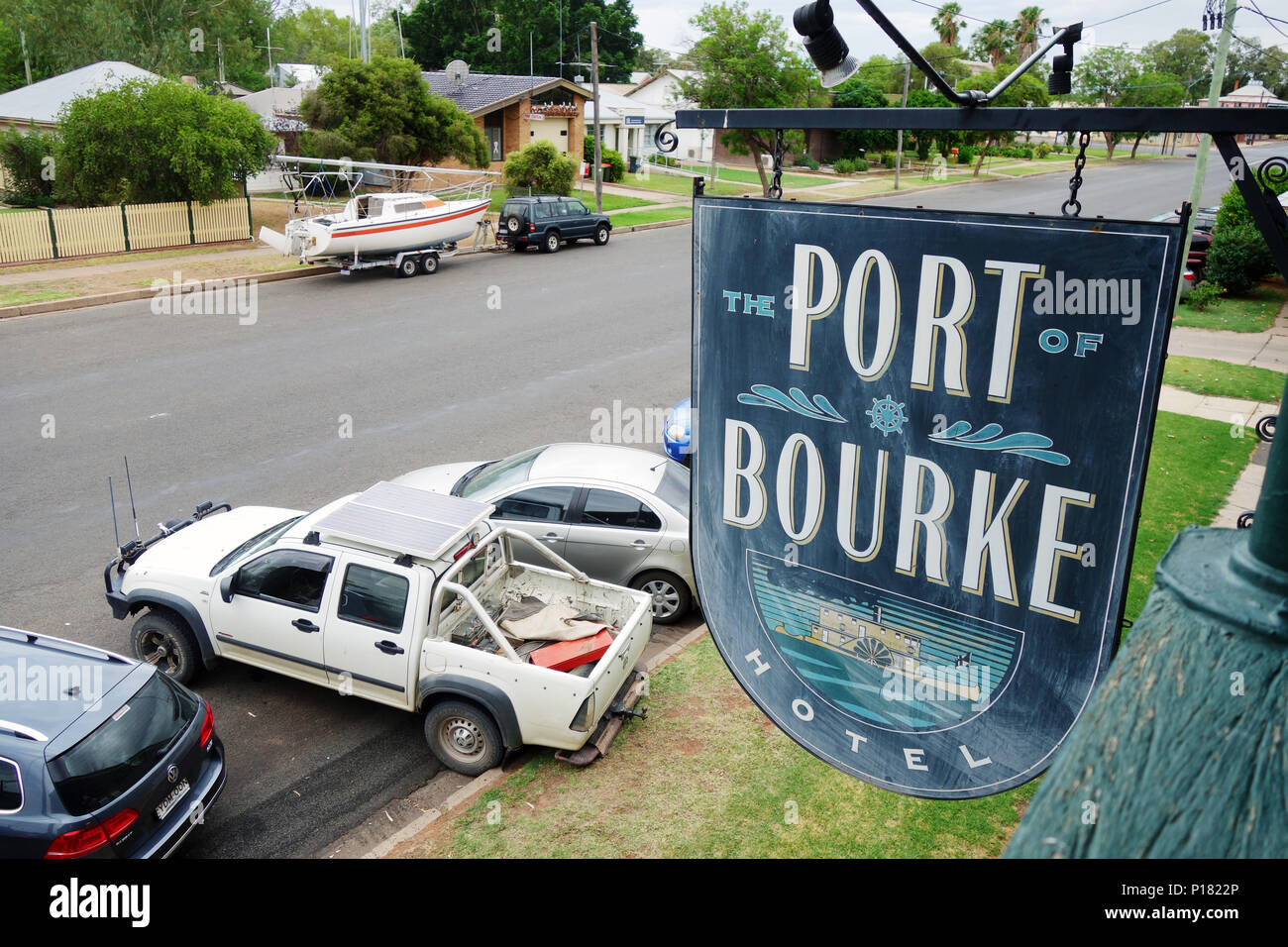 Auto e barca parcheggiato sulla strada di fronte al porto di Bourke Hotel, Bourke, NSW, Australia. N. PR Foto Stock