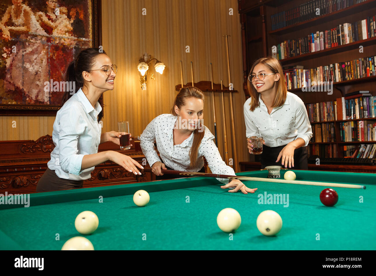 Le giovani donne a giocare a biliardo in ufficio dopo il lavoro. Foto Stock