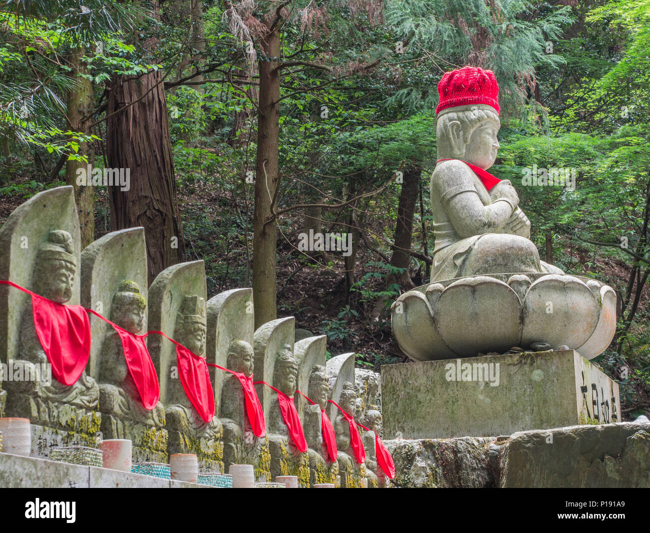 Divinità buddiste, statue con red bibs, tempio Taisanji 52, Shikoku 88 Tempio pellegrinaggio, Ehime in Giappone. Foto Stock