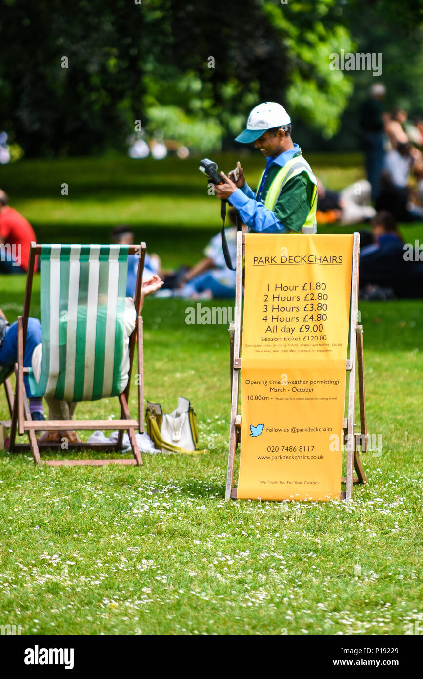 Struttura di poltrona sdraio attendant prendere soldi da visitatori di St James Park, London, Regno Unito. Prezzi per il noleggio di sdraio sul segno. Tempo soleggiato Foto Stock