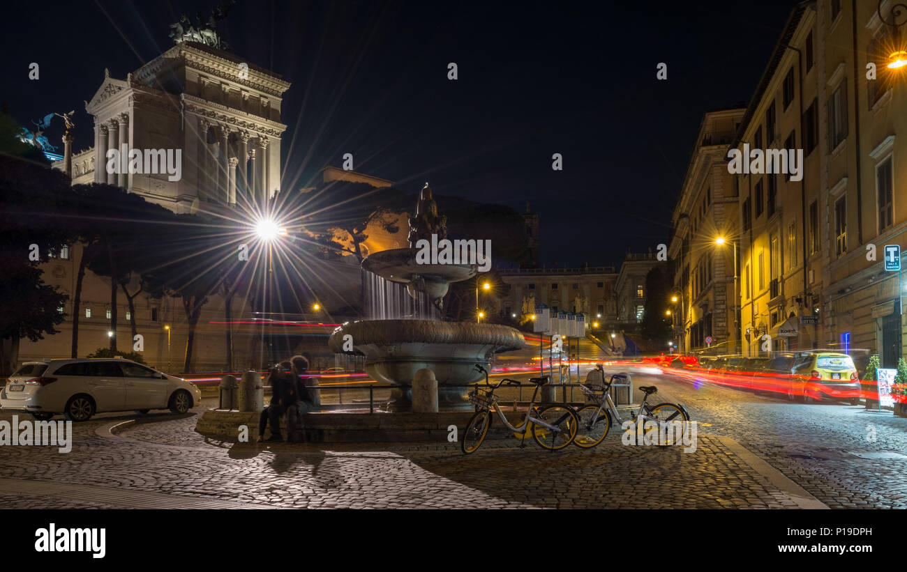 Roma, Italia - 25 Marzo 2018: sentieri di luce sono lasciati dal traffico passante per Via del Teatro di Marcello in una lunga esposizione fotografia dell'Altare Foto Stock