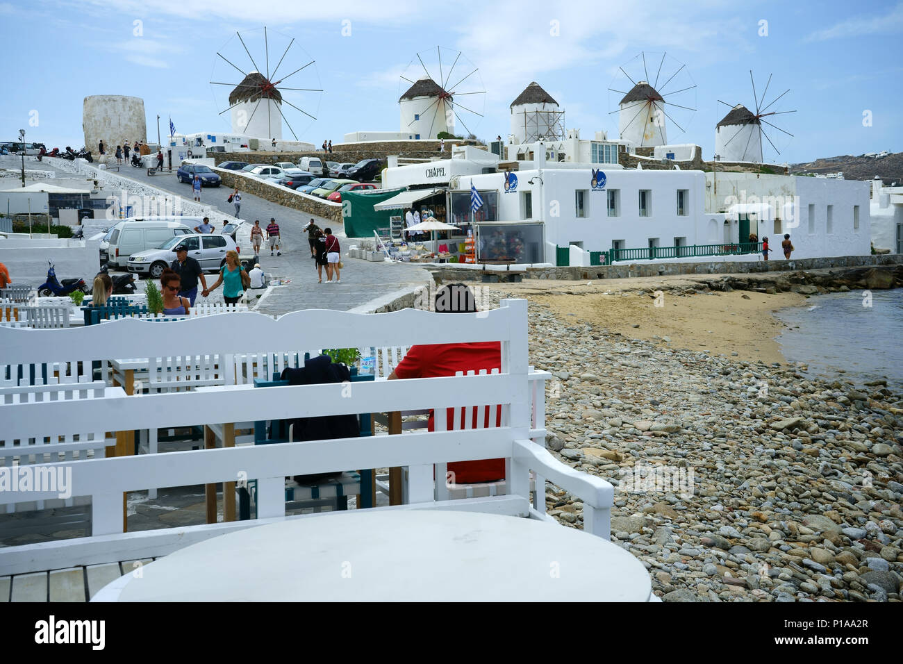 Mulini a vento e street restaurant presso town Myconos, Cicladi, Grecia Foto Stock