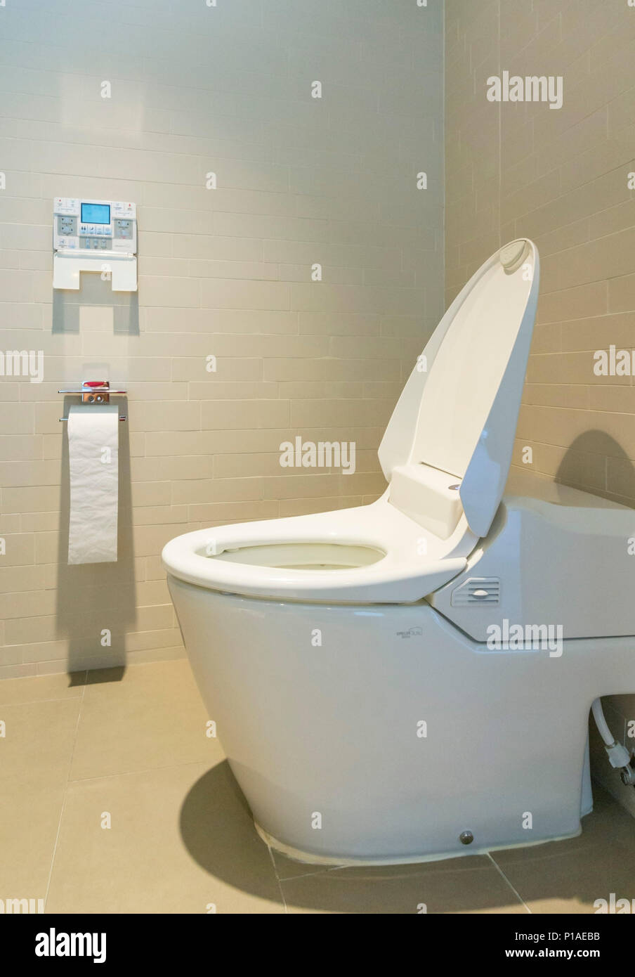 Stile giapponese moderno bagno con bidet funzione di lavaggio smart wc - sistema di flussaggio automatico con varie funzioni di lavaggio ed una parete del pannello di controllo Foto Stock