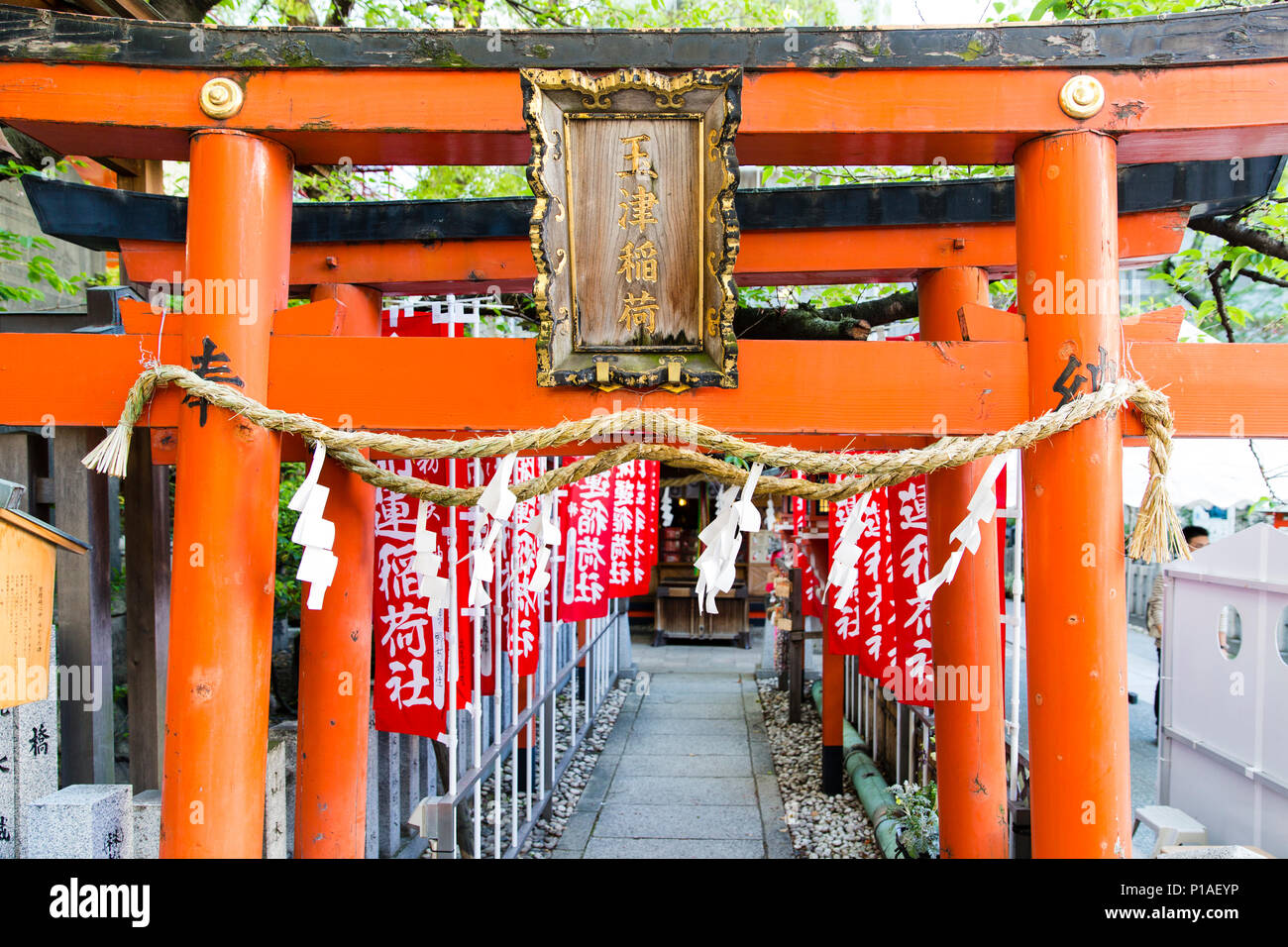 Torii Gate e lo shintoismo bandiere di preghiera che conduce verso la Ohatsu Tenjin santuario di Osaka in Giappone. Foto Stock