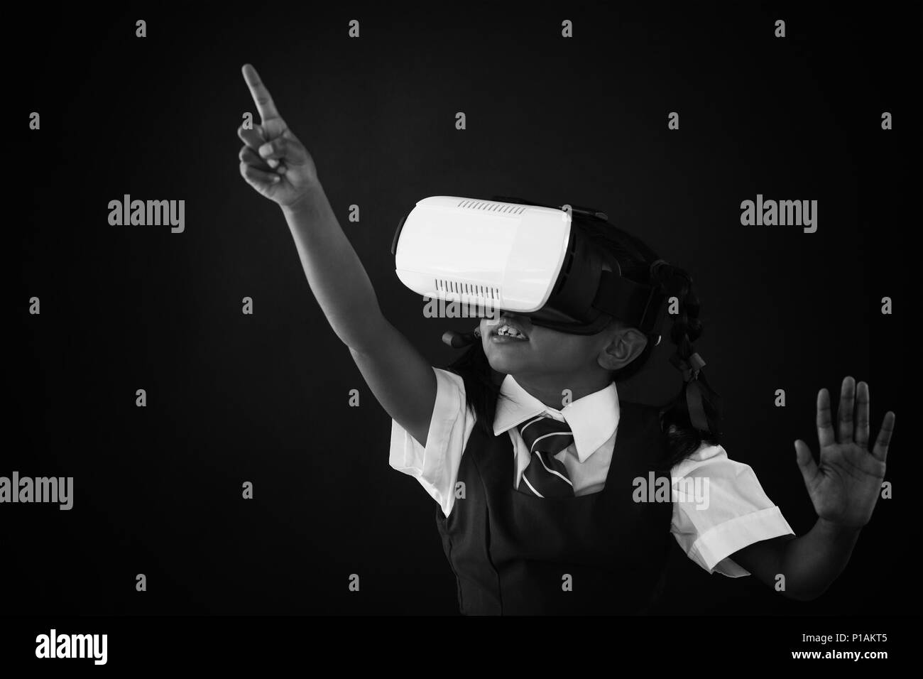 Schoolgirl utilizzando la realtà virtuale auricolare contro di Blackboard Foto Stock