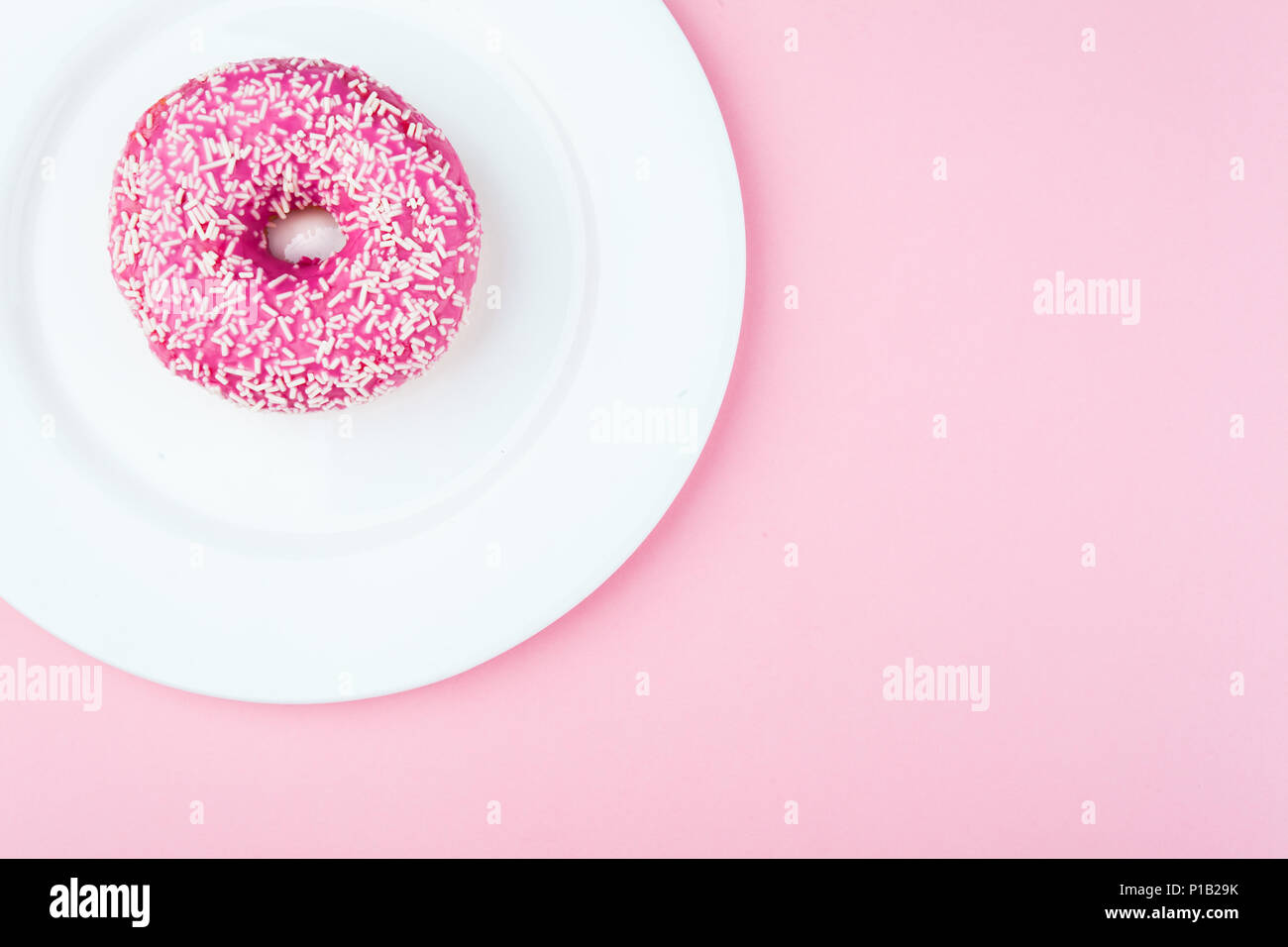 Rosa ciambella smaltata rosa su sfondo pastello Foto Stock