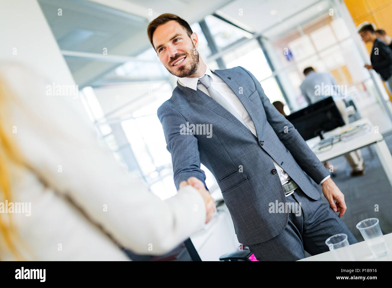 Colleghi di lavoro che stringono le mani dopo la chiusura della trattativa di business Foto Stock