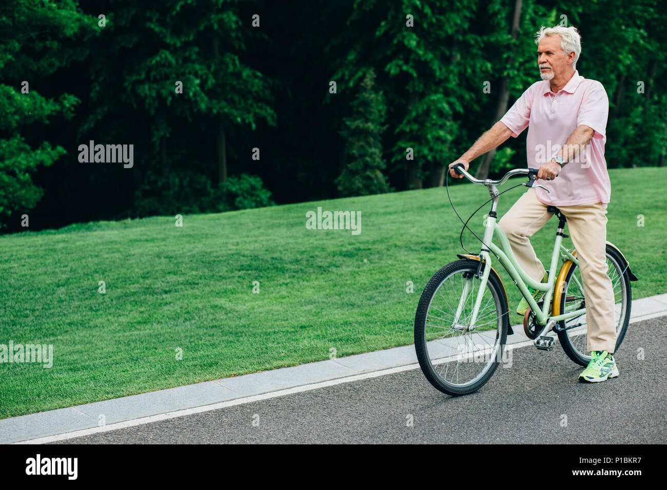 Uomo anziano con una bicicletta, il riposo attivo Foto Stock