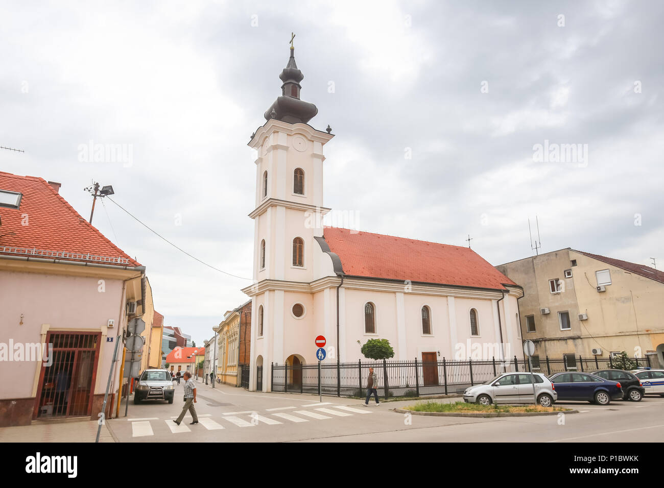 VINKOVCI, Croazia - 14 Maggio 2018 : la gente che passa dalla chiesa cattolica nel centro della città di Vinkovci, Croazia. Foto Stock
