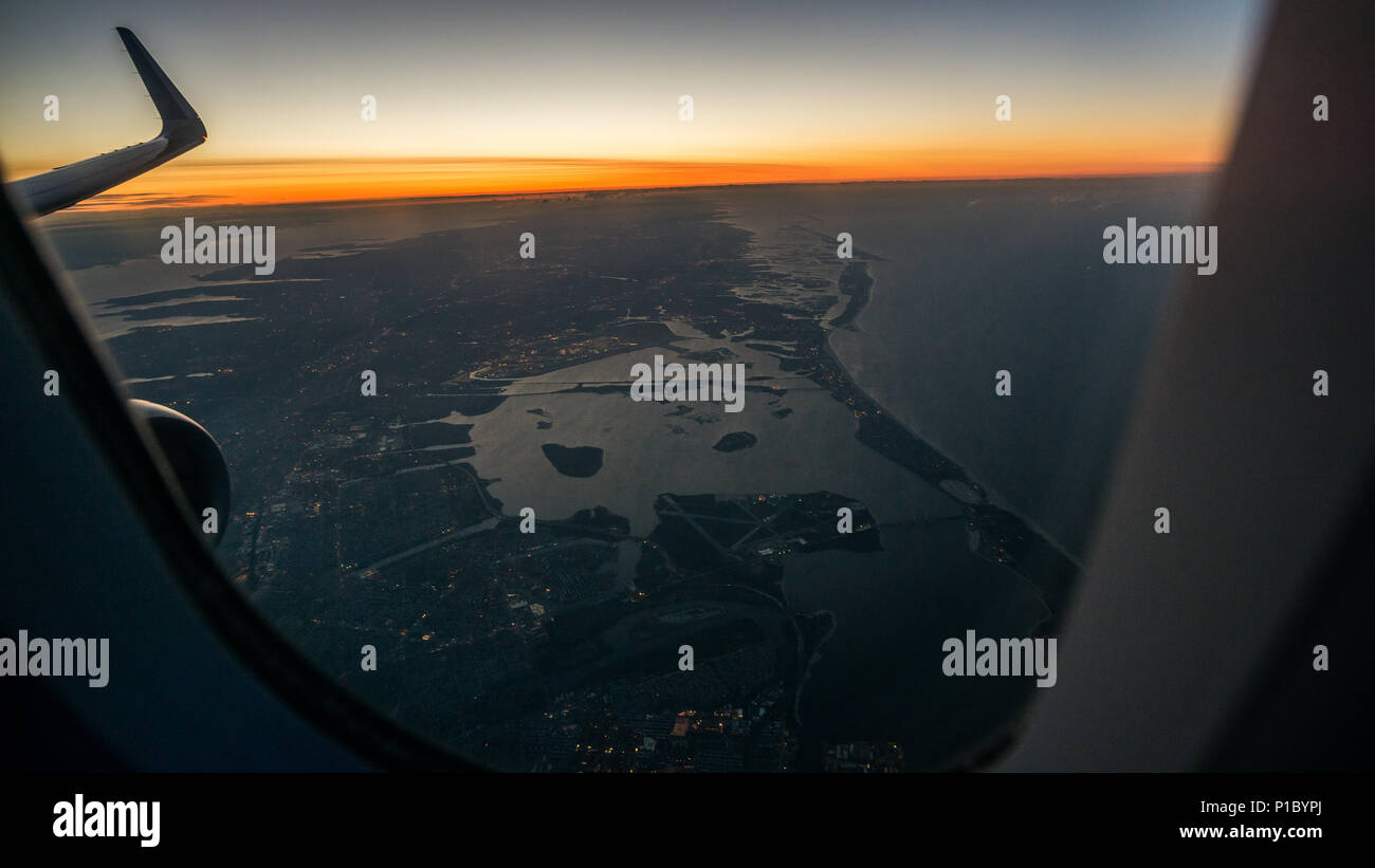 La vista all'alba da un aeroplano finestra poco prima di atterrare all'aeroporto JFK di New York. Foto Stock