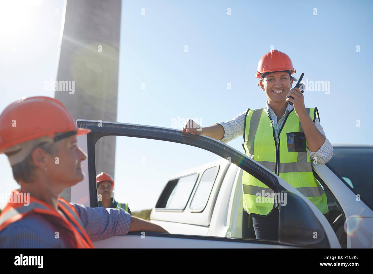 Ritratto sorridente e fiducioso ingegnere femmina utilizzando un walkie-talkie a carrello Foto Stock