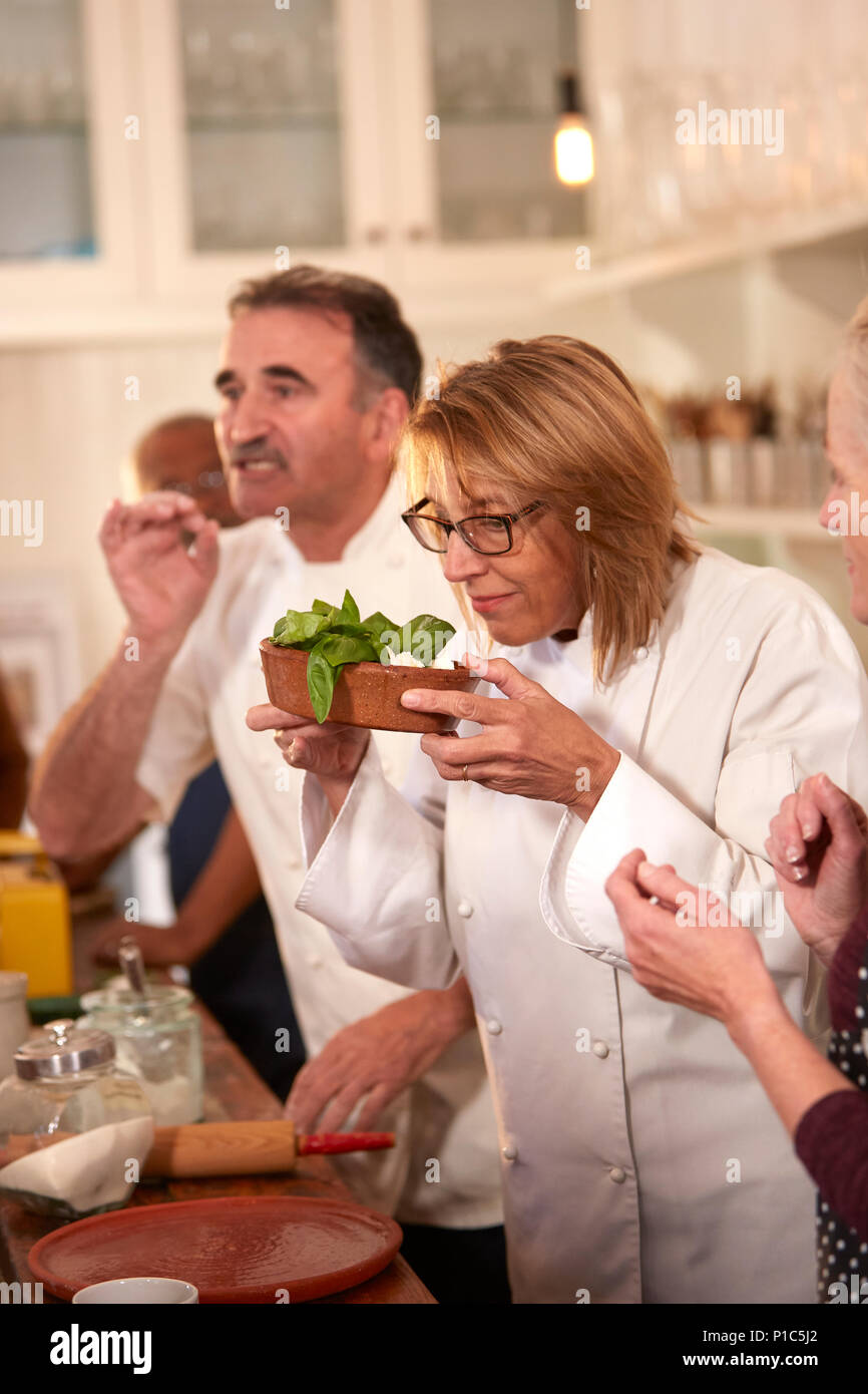 Lo Chef profumati di basilico fresco in classe di cucina Foto Stock