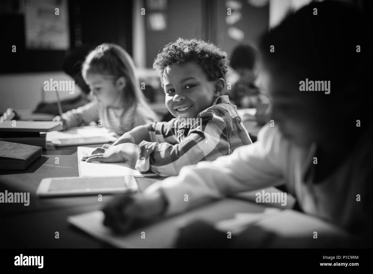 Ritratto di sorridere schoolboy facendo i suoi compiti in classe Foto Stock