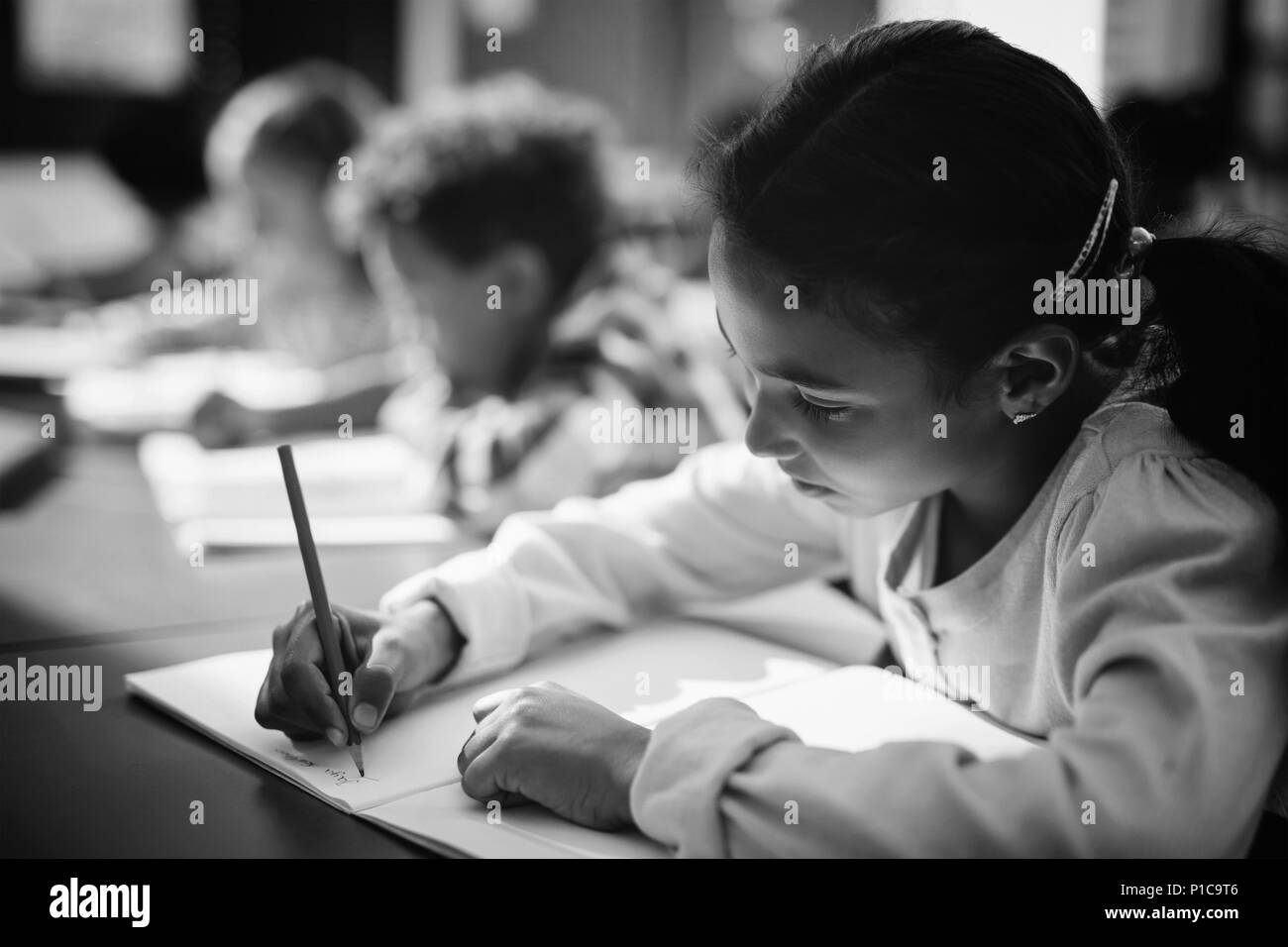 Attento schoolgirl facendo i suoi compiti in classe Foto Stock
