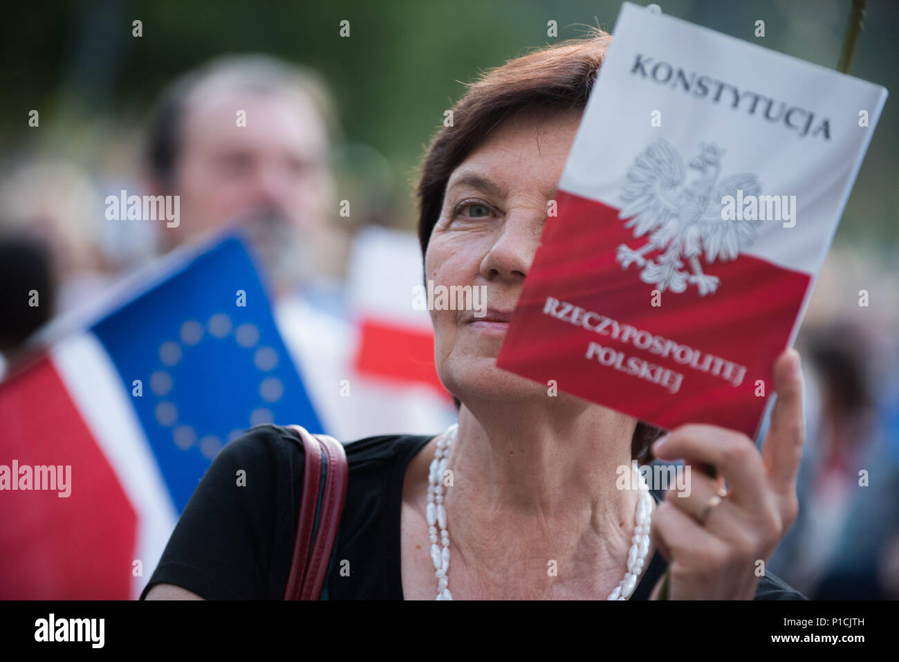 Una donna può contenere una costituzione polacca durante una manifestazione di protesta a favore della Commissione europea che spinge i leader dell'UE a premere in avanti con azioni disciplinari contro la Polonia per presunta violazione regola di norme di legge davanti ai tribunali di Cracovia. Nel mese di dicembre la Commissione europea ha lanciato un articolo 7 procedimento disciplinare, che in teoria potrebbe condurre alla sospensione di Polonia dell'UE per il diritto di voto. La Commissione europea ha dato la Polonia fino alla fine di giugno per invertire le riforme introdotte dal governo attuale ma non sono state apportate modifiche fino ad oggi. Le proteste sono organizzate da KOD ( Comitato Foto Stock