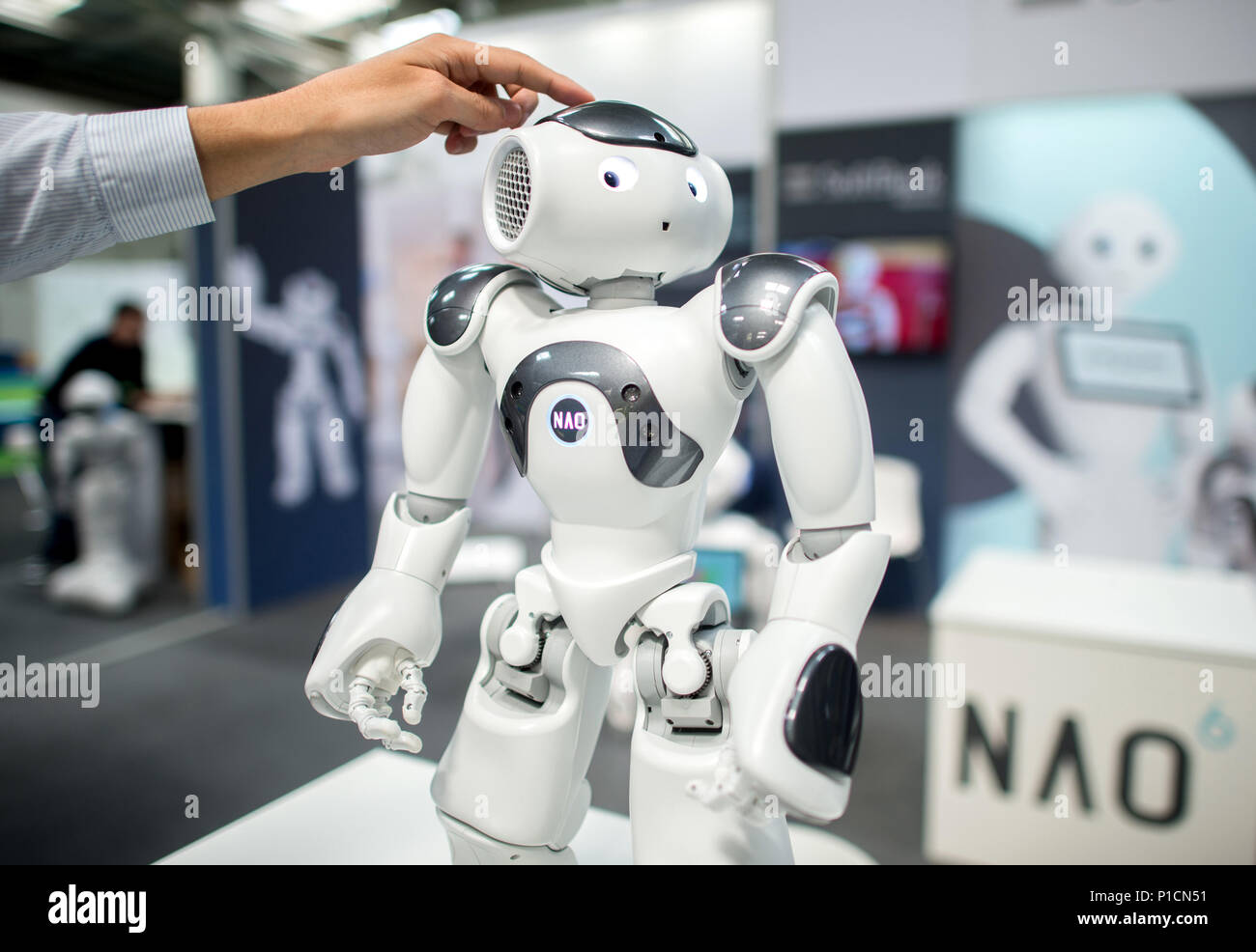 11 giugno 2018, Hannover, Germania: un uomo opera il robot "NAO' a SoftBank Robotics stand alla fiera digitale "Cebit'. Il Cebit è il tentativo di un nuovo 'festival' formato dopo tre decenni, che si svolge tra l'XI e il XV di giugno. Foto: Hauke-Christian Dittrich/dpa Foto Stock