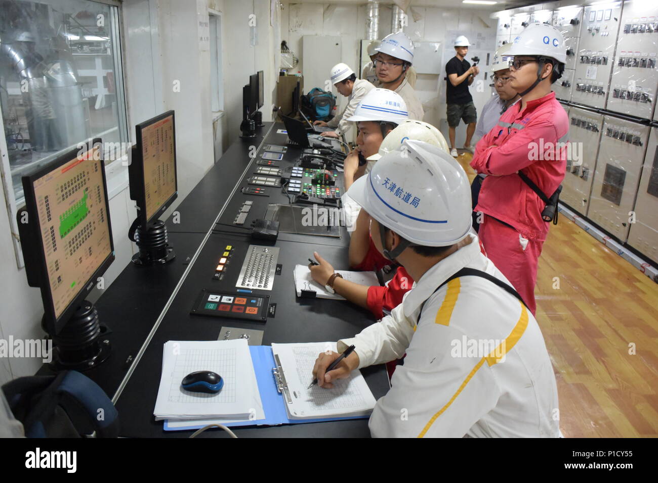 (180612) -- QIDONG, 12 giugno 2018 (Xinhua) -- i membri dello staff lavorano presso la sala di controllo su Tian Kun Hao, cinese-costruito il dragaggio di nave, il più grande del suo genere in Asia, 7 giugno 2018. Tian Kun Hao, costruito mediante dragaggio di Tianjin Co. Ltd., una controllata della Cina Costruzione Comunicazione Co., Ltd. (CCCC), terminata la sua prima prova in mare. Il 140-metro-nave lunga, con la capacità progettata per dragare 6.000 metri cubi ora, può scavare profonde come 35 metri sotto il fondo del mare. (Xinhua/Mao Zhenhua) (wyl) Foto Stock