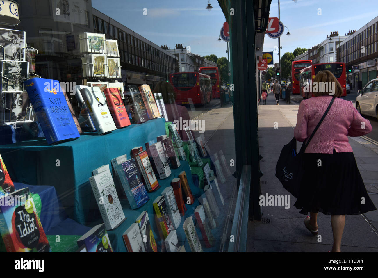 La gente a piedi passato un bookshop indipendente su Kentish Town Road. Negozi stanno chiudendo e la high street è in declino in quanto le persone si spostano per fare loro sho Foto Stock