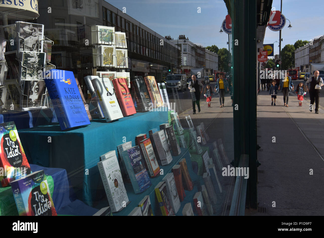 La gente a piedi passato un bookshop indipendente su Kentish Town Road. Negozi stanno chiudendo e la high street è in declino in quanto le persone si spostano per fare loro sho Foto Stock