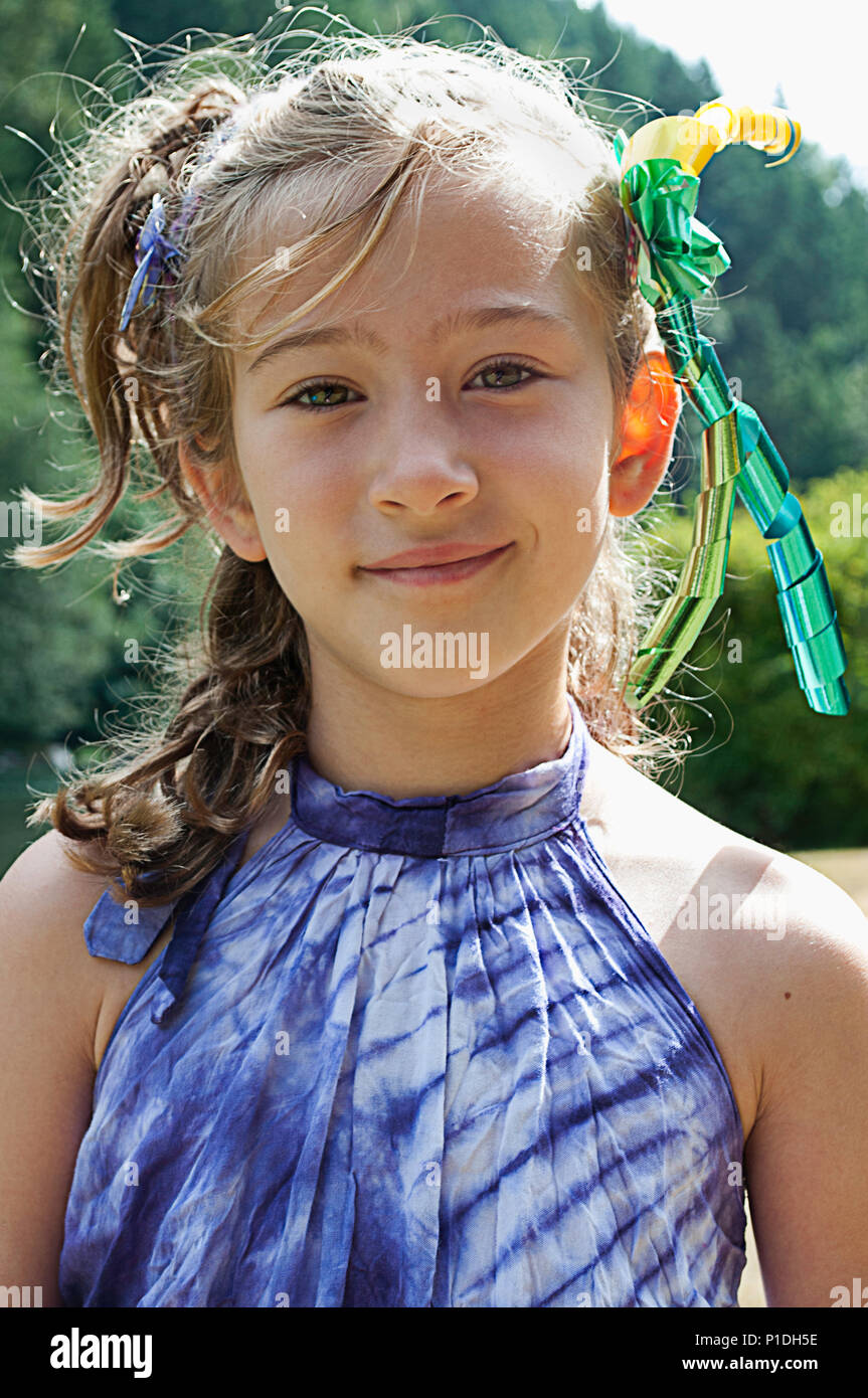 Una giovane ragazza che indossa i nastri tra i capelli, sorridente alla fotocamera. Foto Stock