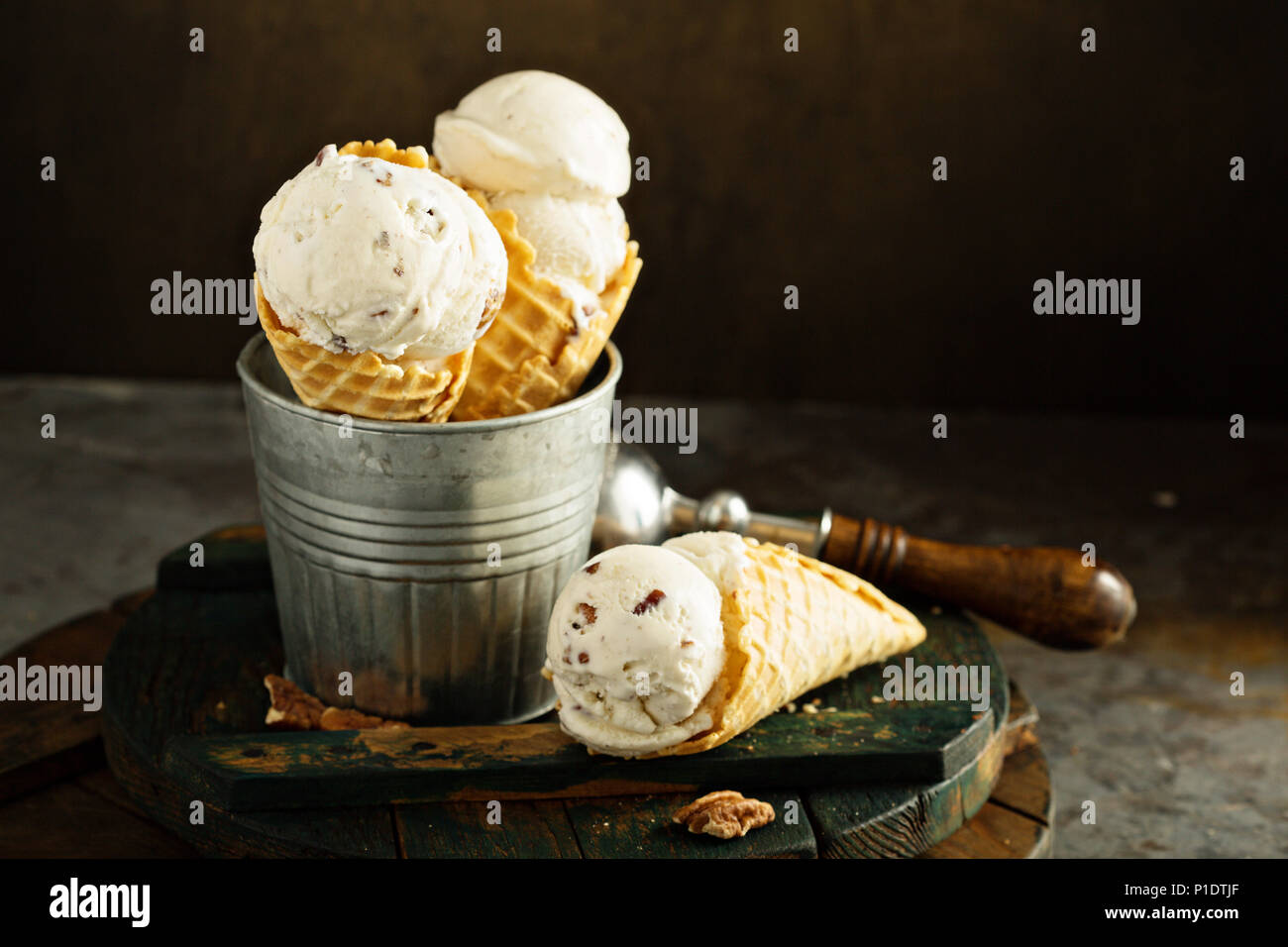 Il burro di noci pecan tagliate a gelato in cialda coni Foto Stock
