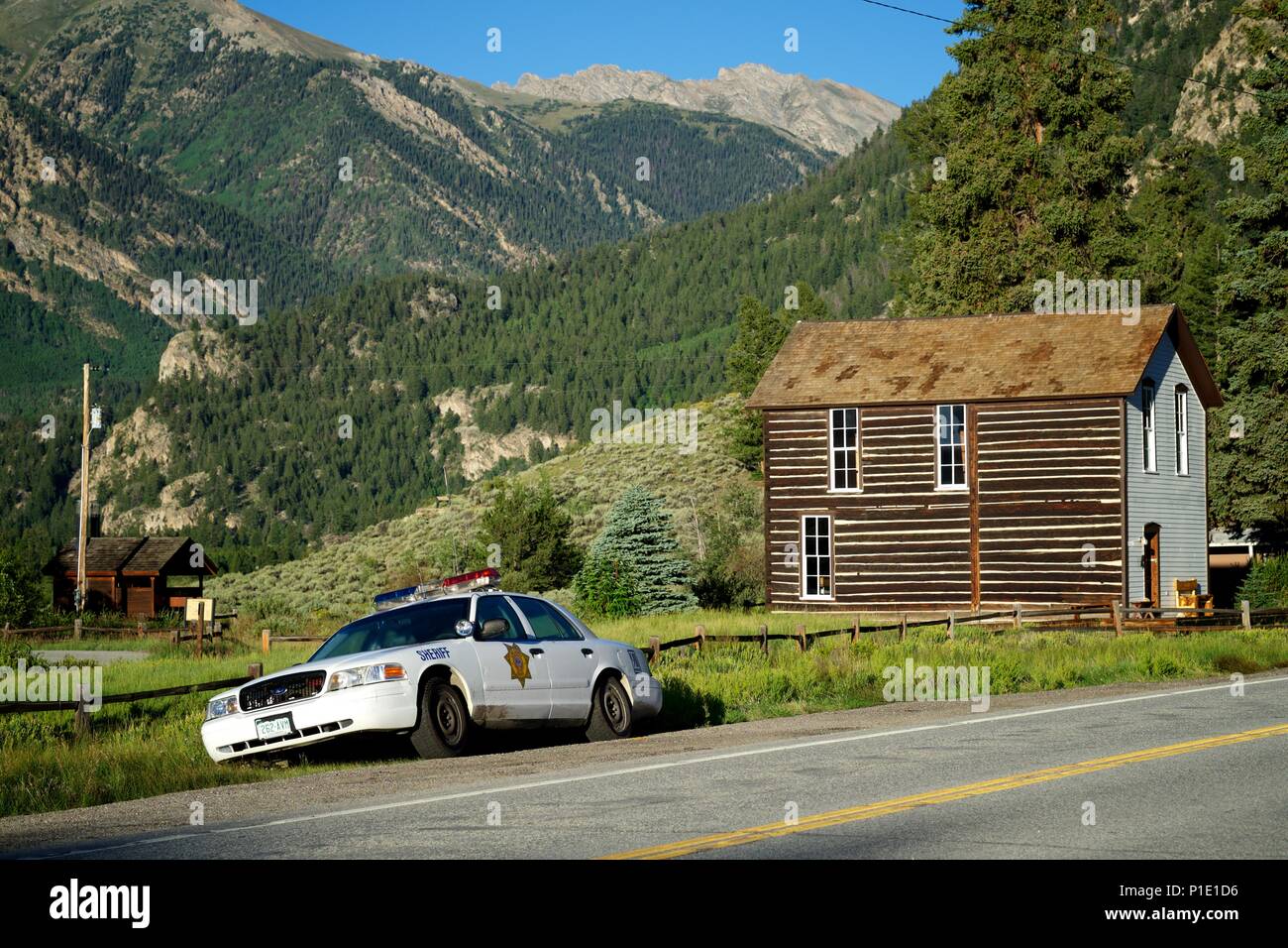 American automobile della polizia su una strada prima di una cabina e montagne Foto Stock