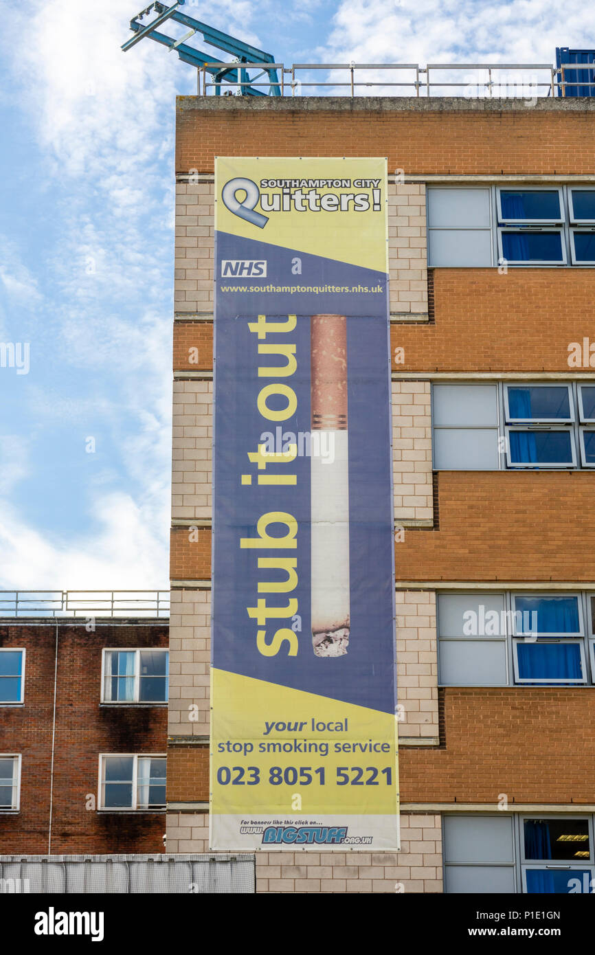 "Vasca fuori' Banner per il NHS locale "Quitters smettere di fumare service' lungo un edificio presso il General Hospital di Southampton, England, Regno Unito Foto Stock